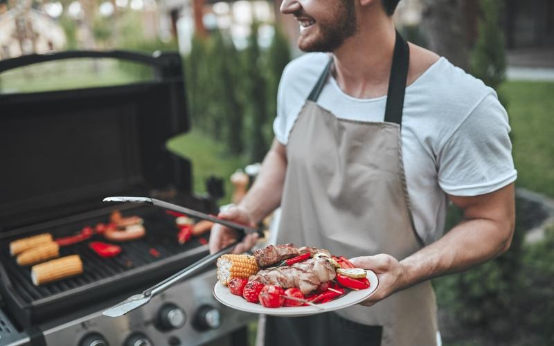 a man holding a plate of grilled food