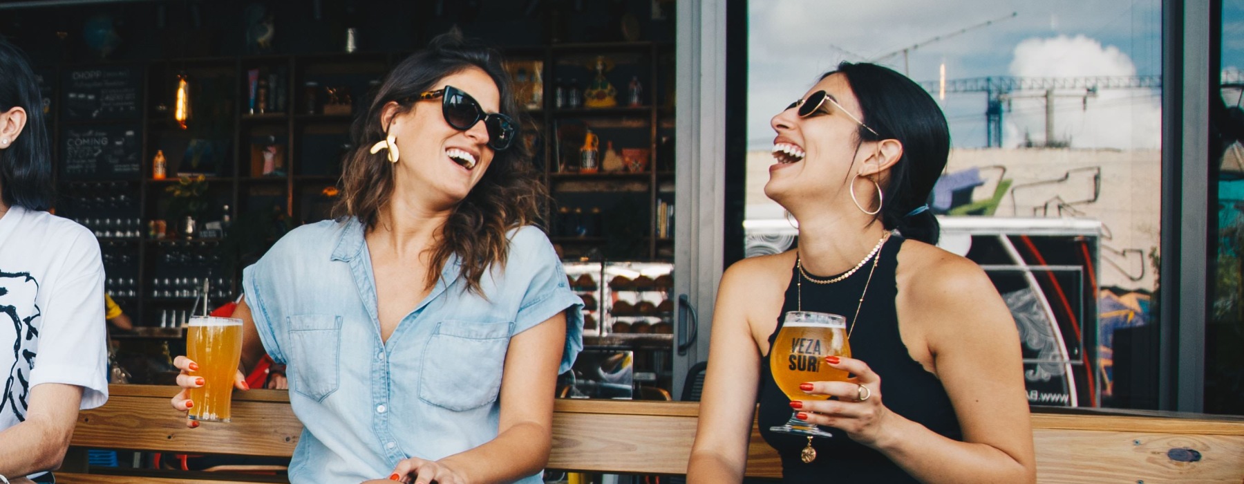 women sitting drinking a beer